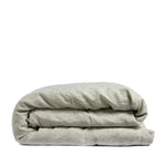 By Mölle's sage linen duvet cover, crafted from 100% pre-washed European flax linen, features a soft grey-green hue achieved through chambray weaving. This breathable and hypoallergenic fabric offers comfort year-round and is available with either wooden buttons or a tuck-in flap closure.