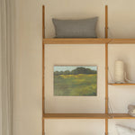 Wooden shelf against a wall with decorative items including a painting and pillows.