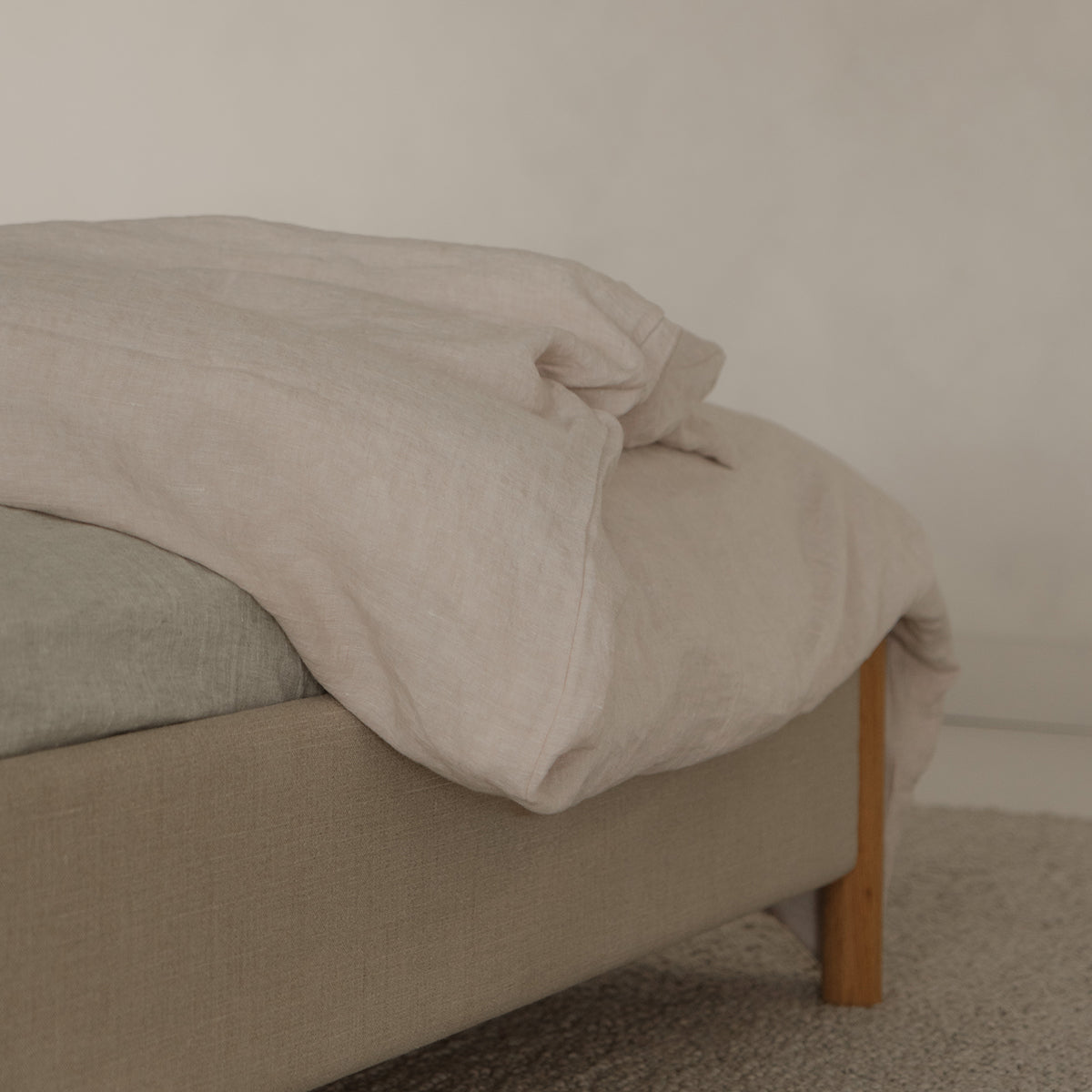 Veng bedframe met linnen beddengoed in de lichtbeige kleur alabaster.