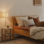 Ejer Bed Frame by RYE available in oiled oak, black stained oak, or smoked oak finishes, featuring a minimalist design with clean lines and a slightly inclined headboard, crafted for a tranquil and restful sleep environment