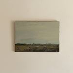 Small landscape painting on a beige wall