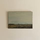 Small landscape painting on a beige wall