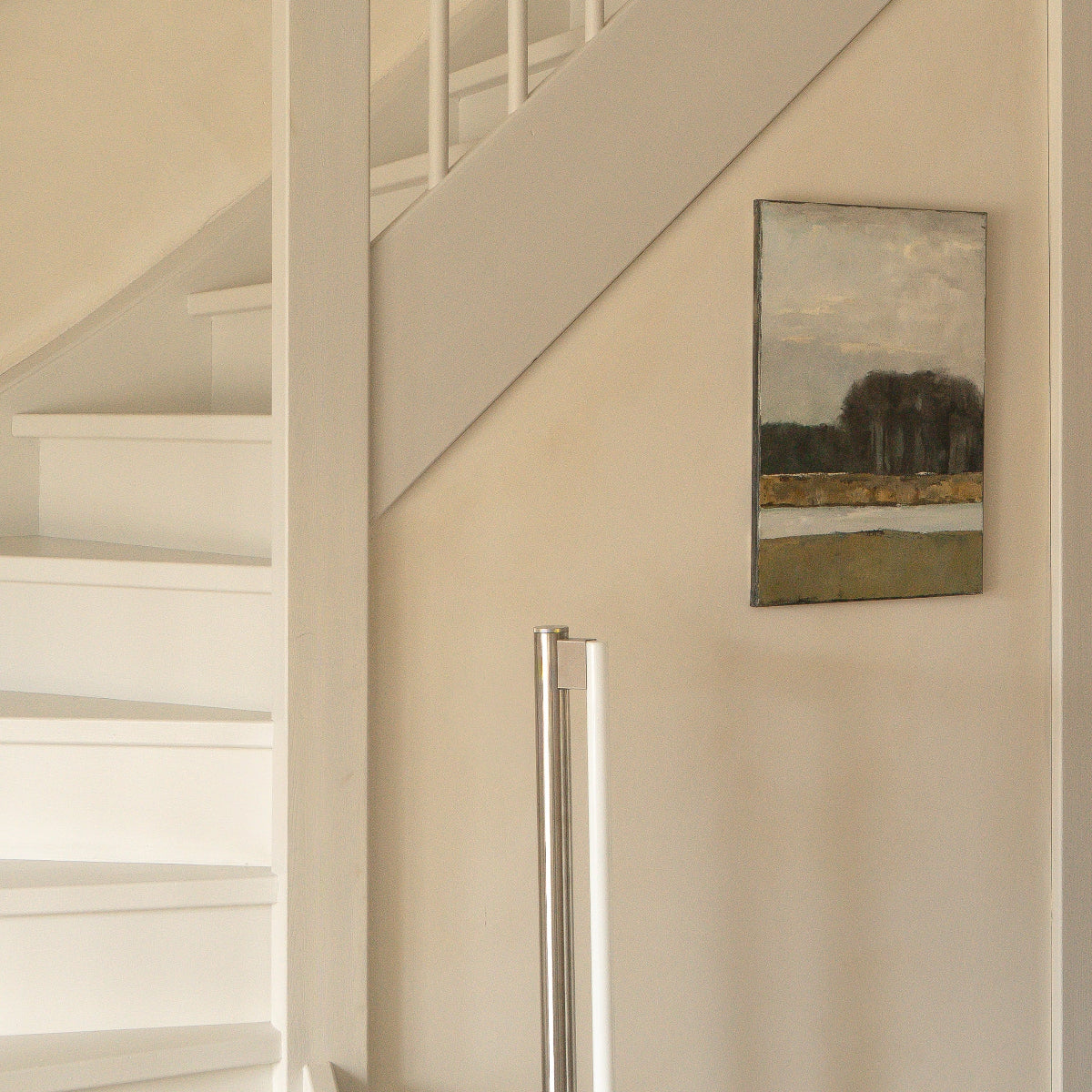 Modern interior with a staircase, wall art, and a floor lamp.