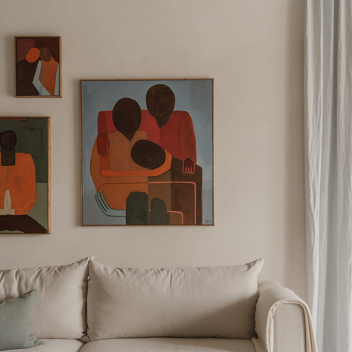 Artistic wall decorations above a beige sofa in a room with neutral tones.