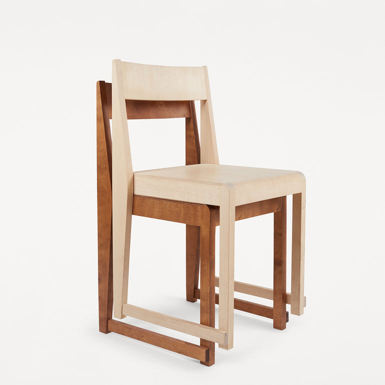 Stacked Frama chair 01's in warm brown birch and natural birch