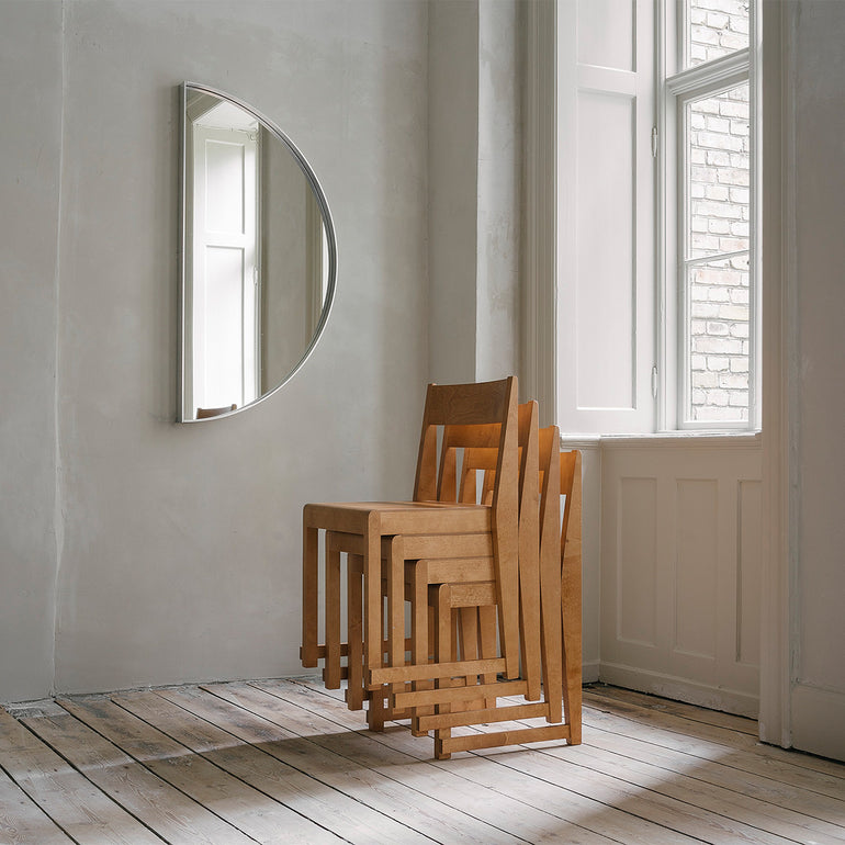Stacked Frama chairs in a room with a mirror