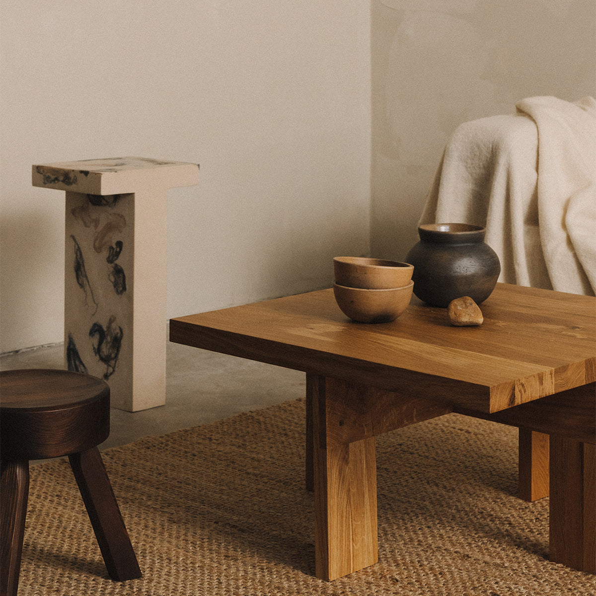 Frama farmhouse coffee table square in a setting with a rug, a statue and the AML stool by Frama