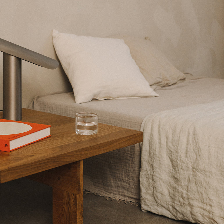 Frama farmhouse table as a bedside table, with a bed pictured in the background
