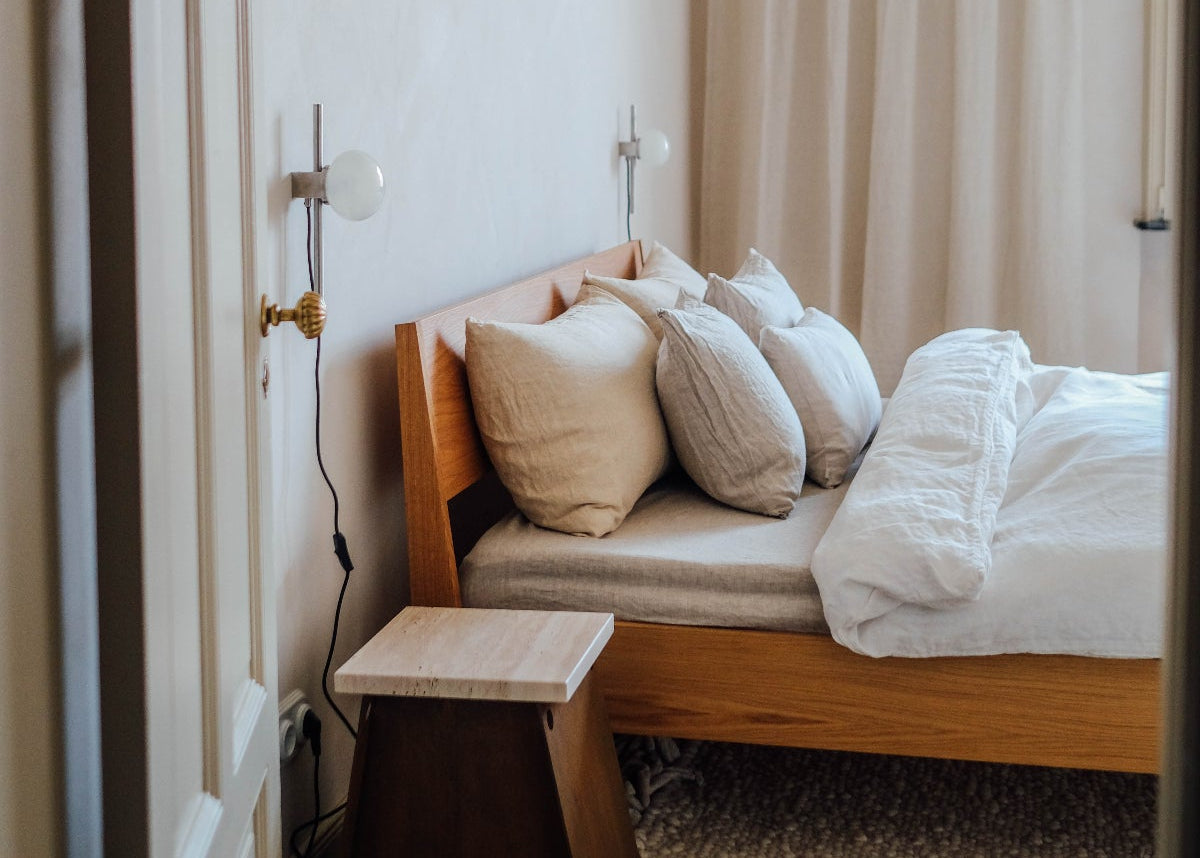 Ejer bed frame met By Mölle linnen beddengoed en in between linnen gordijnen.
