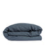By Mölle's Faded Blue linen duvet cover, crafted from 100% pre-washed European flax linen. This soft blue shade complements various interior styles, offering a serene and natural ambiance. The duvet cover features a choice of wooden buttons or a full-width tuck-in flap closure, combining functionality with timeless design.
