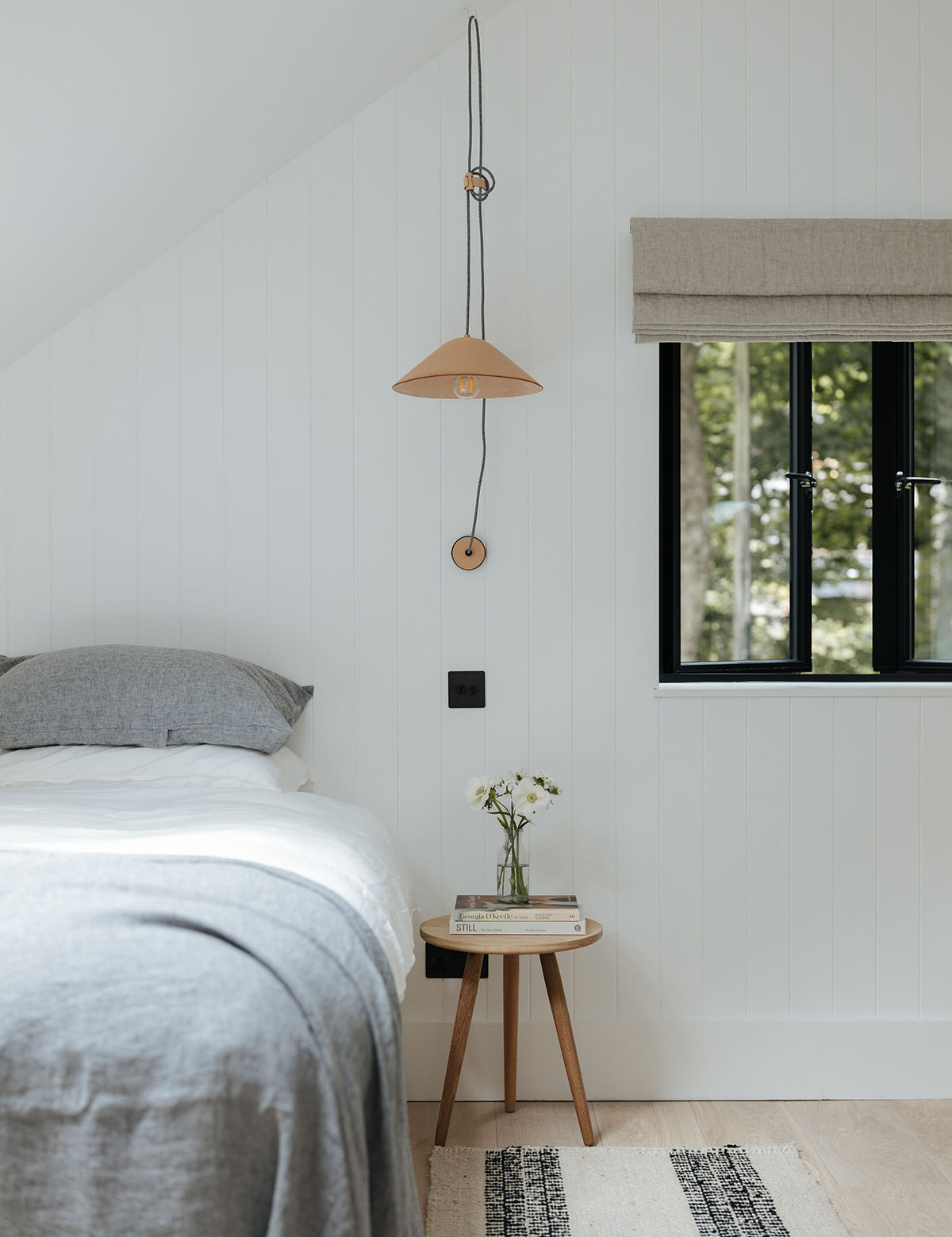 Slaapkamer met By Mölle linnen beddengoed en vouwgordijn in naturelle kleuren.