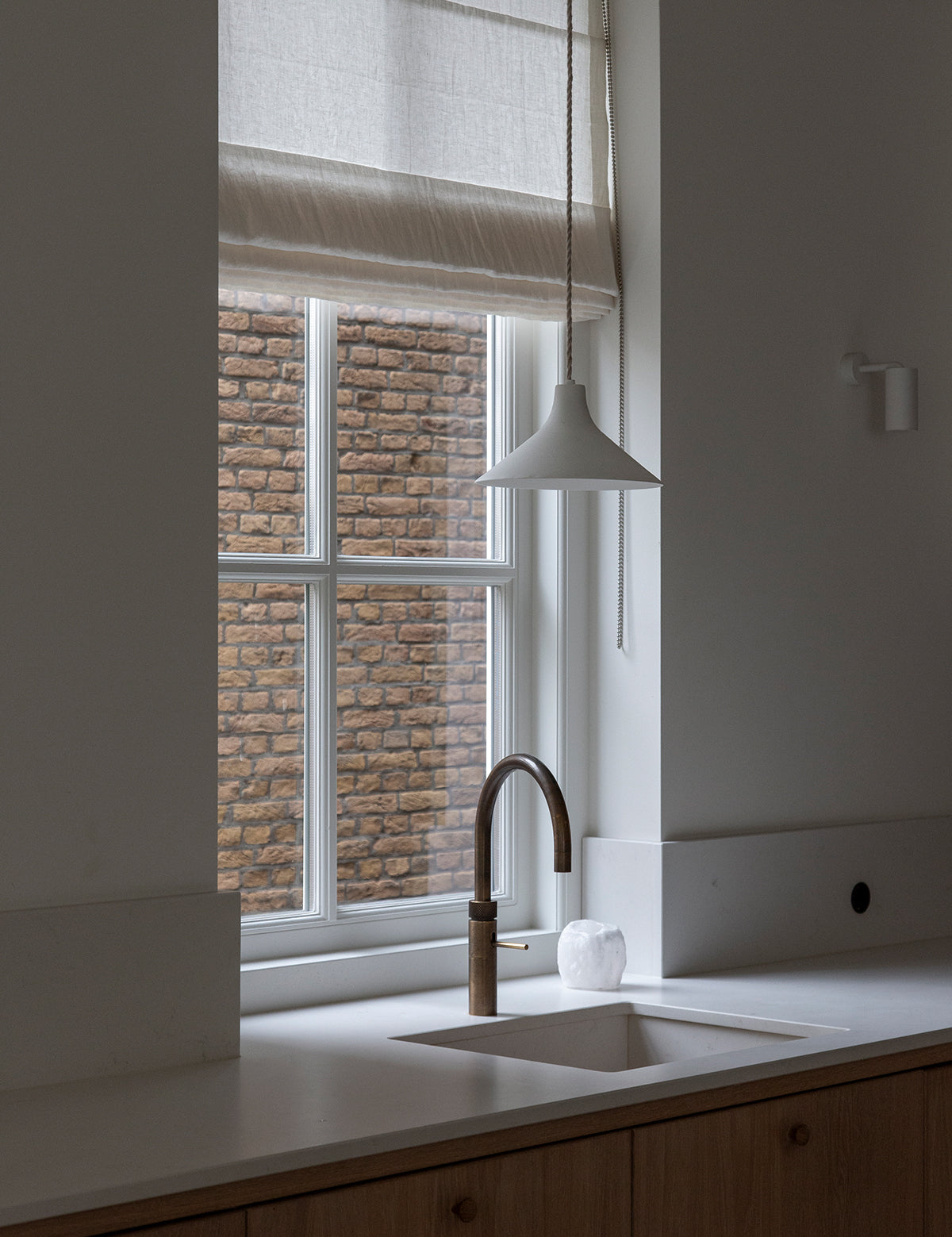 Warm wit linnen vouwgordijn van By Mölle in een moderne keuken. 