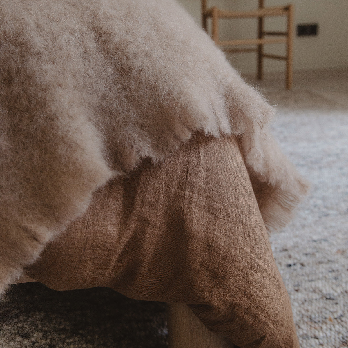 Close-up of a textured brown blanket on a chair with a blurred background