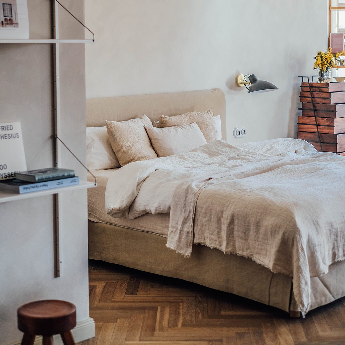 Opgemaakt bed met linnen beddengoed van By Mölle in de kleuren warm white en sea shell.