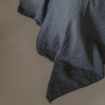 Dark gray linen fabric on a beige underground
