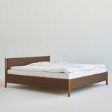 Minimalistisch houten bedframe, ontworpen door Rye Sleep en verkrijgbaar bij By Mölle. Met strakke Scandinavische lijnen, een laag silhouet en een zacht gestoffeerd hoofdbord combineert dit bed tijdloos design met natuurlijke materialen voor een rustige, moderne slaapkamer.