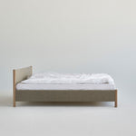 Minimalistisch houten bedframe, ontworpen door Rye Sleep en verkrijgbaar bij By Mölle. Met strakke Scandinavische lijnen, een laag silhouet en een zacht gestoffeerd hoofdbord combineert dit bed tijdloos design met natuurlijke materialen voor een rustige, moderne slaapkamer.