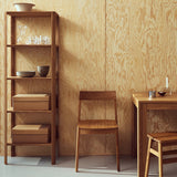 Minimalist tall shelving unit made of solid European oak, featuring sculptural leaf-shaped legs and a clean design without visible screws. Perfect as a room divider, sideboard or freestanding shelving.
