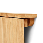 Minimalist folding wall table made of solid oak with a slender frame and concealed hinge mechanism. Oval tabletop folds away easily, ideal for small spaces.