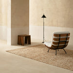 the panama rug in papyrus in a setting with chair, stool and lamp
