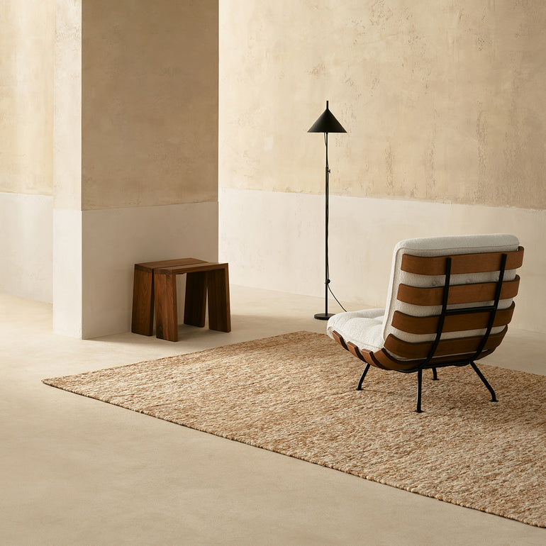 the panama rug in papyrus in a setting with chair, stool and lamp
