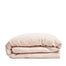 By Mölle's blush linen duvet cover, crafted from 100% pre-washed European flax linen, features a soft, powdery pink hue achieved through chambray weaving. This breathable and hypoallergenic fabric offers comfort year-round and is available with either wooden buttons or a full-width tuck-in flap closure.