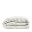 By Mölle's Cocoa Stripe linen duvet cover, crafted from 100% pre-washed European flax linen, features a warm white base with subtle cocoa-colored stripes. The chambray weave adds depth and character, offering a breathable and hypoallergenic fabric suitable for year-round comfort. Available with either wooden buttons or a full-width tuck-in flap closure.