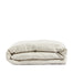 By Mölle's Sea Shell linen duvet cover, crafted from 100% pre-washed European flax linen, features a soft beige and off-white chambray weave. This breathable and hypoallergenic fabric offers comfort year-round and is available with either wooden buttons or a tuck-in flap closure. Handmade in the Netherlands with respect for the earth.